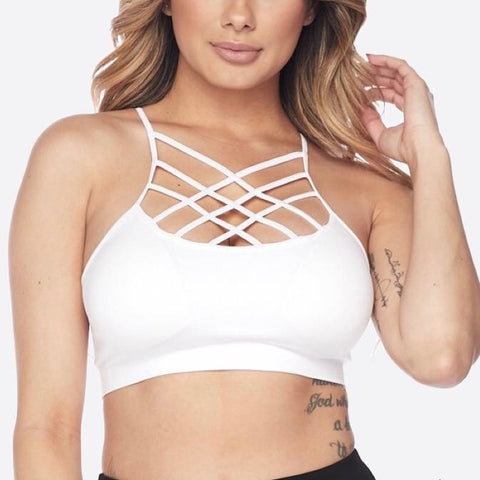 White trendy sports bra with cris-cross strapping in the front, worn on a female model.
