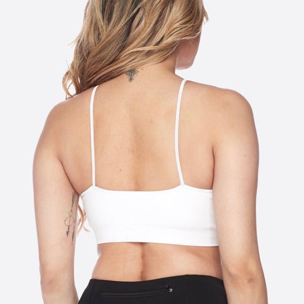 White trendy sports bra with cris-cross strapping in the front, back view on model.