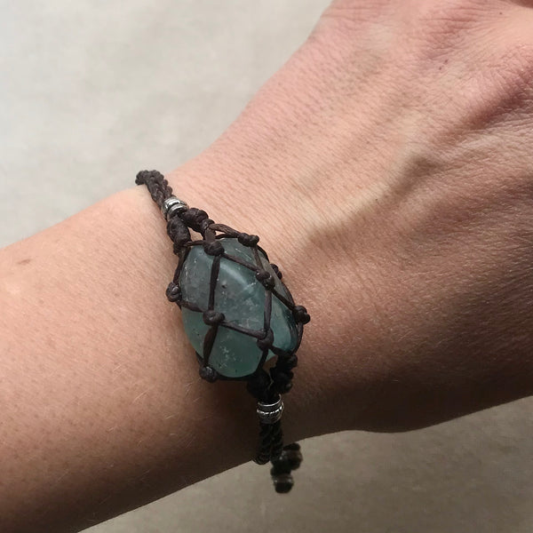 Macrame Crystal Pouch Bracelet with Fluorite, close up on woman's wrist.